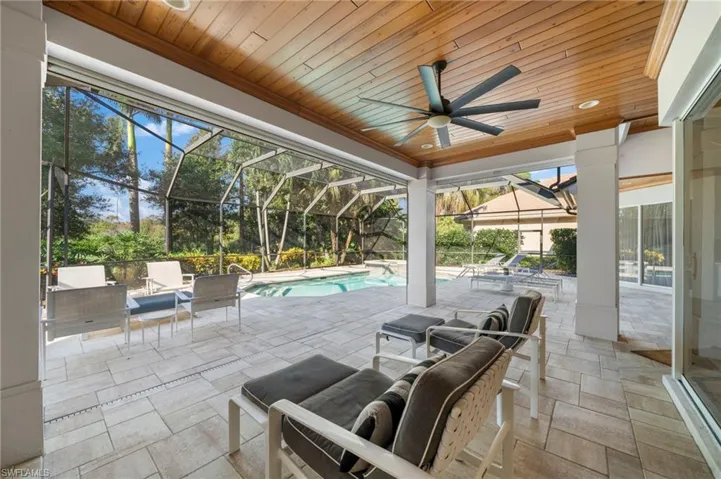View of patio featuring glass enclosure and ceiling fan