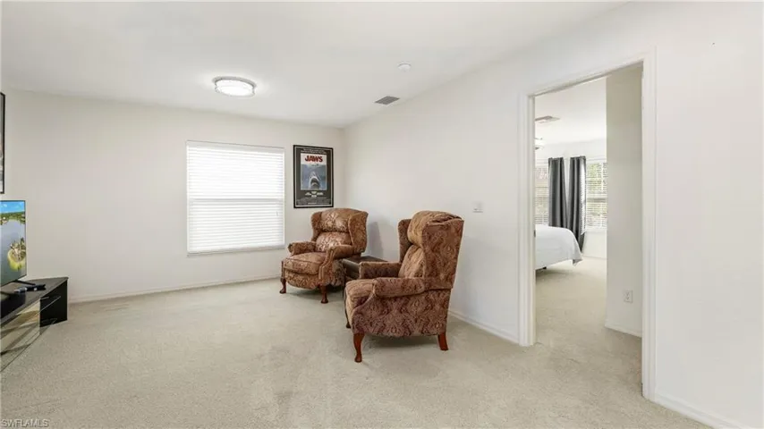 Loft with light carpet and baseboards