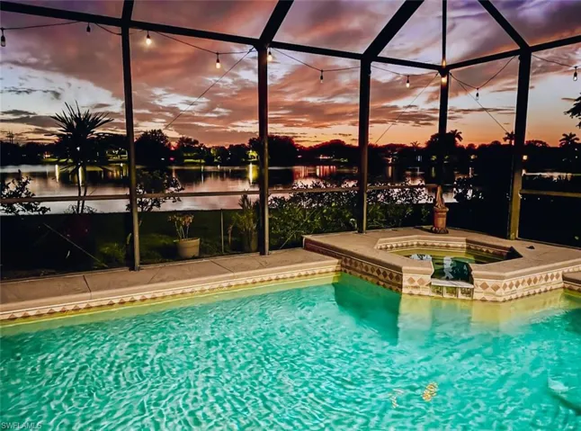 Combined pool / hot tub featuring a screened lanai