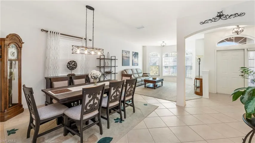 Dining room featuring arched walkways and light tile patterned floors