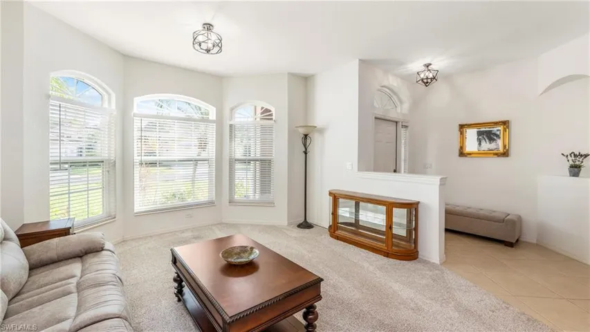 Living area with healthy amount of natural light, light colored carpet, and light tile patterned floors