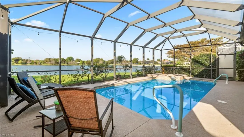 Combined pool / hot tub featuring a sunroom, a lanai, a patio, and a water view