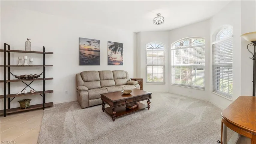 Living area with light carpet and light tile patterned floors