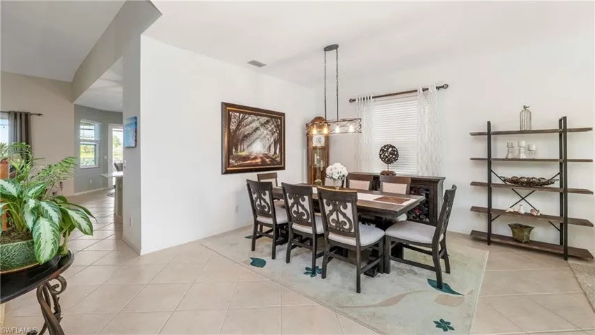Dining area featuring light tile patterned floors and baseboards