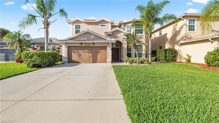Mediterranean / spanish-style house featuring stucco siding, a front yard, driveway, a garage, and a tiled roof