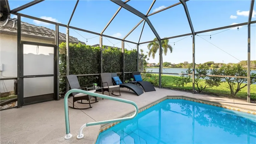 Outdoor pool with a lanai, a sunroom, and a water view