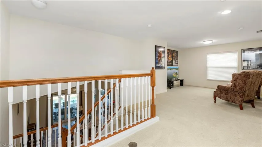 Loft with light colored carpet and baseboards