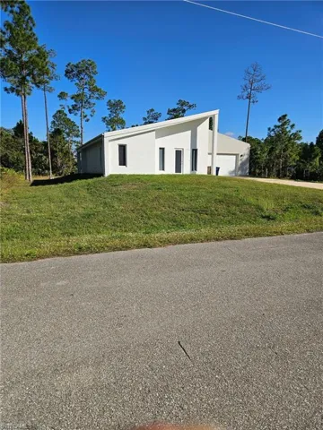View of front facade with stucco siding and a front lawn