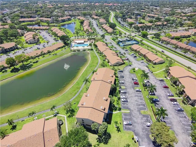 Aerial perspective of a multi-building residential community featuring multiple water bodies, mature landscaping, and varied rooflines