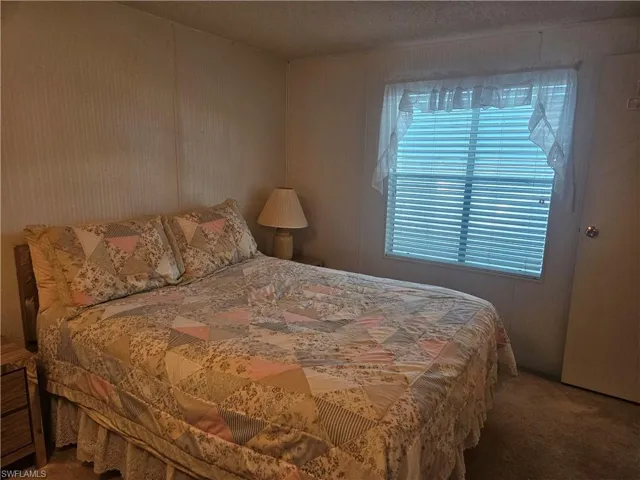 Carpeted bedroom with a textured ceiling
