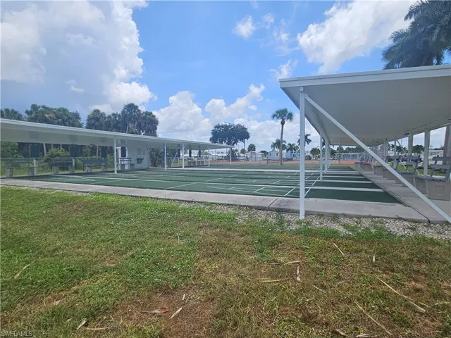 View of home's community featuring shuffleboard and a yard
