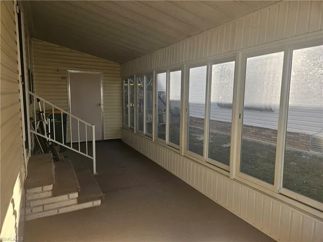 Unfurnished sunroom with lofted ceiling