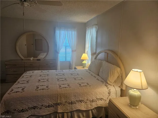 Bedroom with a textured ceiling and ceiling fan