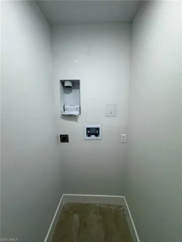 Dedicated laundry area with tile flooring and light gray walls