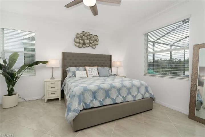Large primary bedroom with tile flooring, dual closets.