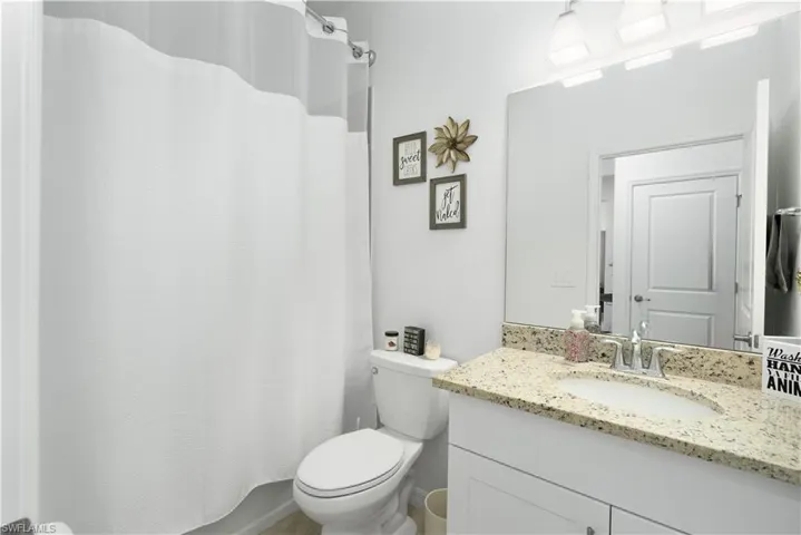 Main bathroom with tiled tub/shower combo.