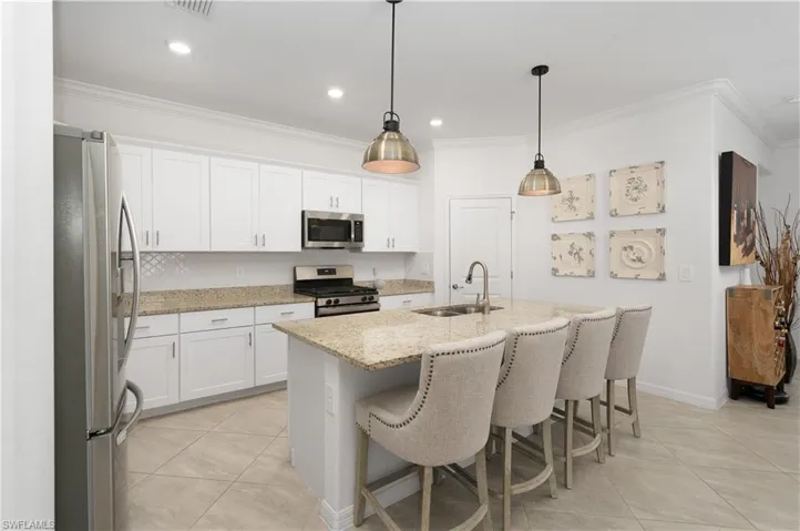Kitchen has White Shaker Style Cabinetry, sink has a garbage disposal, over the island modern pendant lighting and a natural GAS stove for cooking your favorite meals.