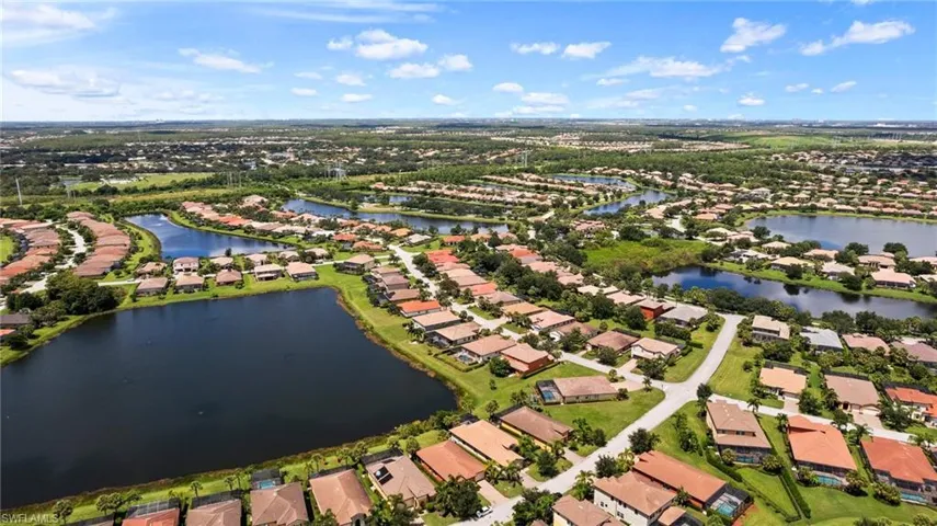 Aerial view of property and surrounding area with nearby suburban area and a large body of water