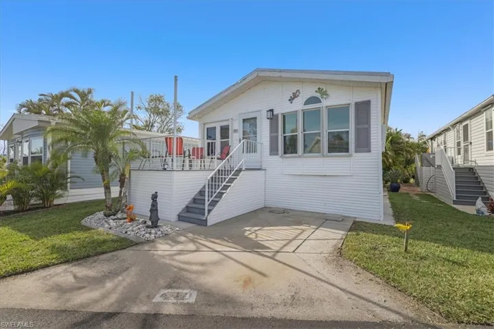 View of front of house featuring stairway, a front yard, and a patio area