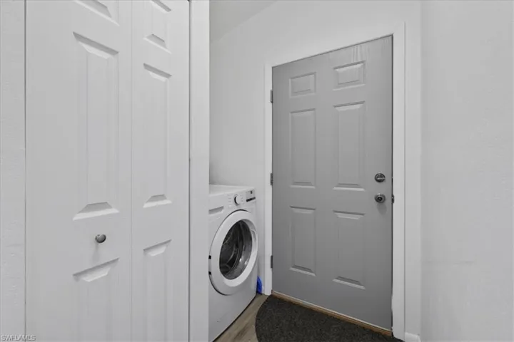 Washroom with washer / clothes dryer and wood finished floors