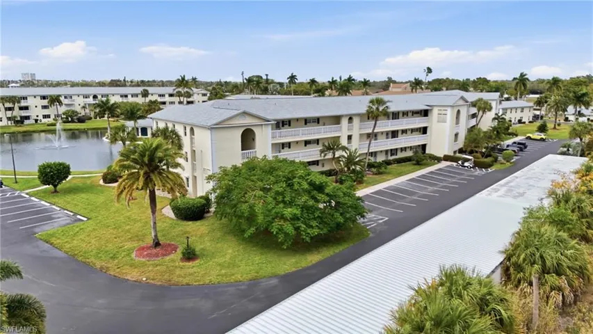 View of apartment building / complex with uncovered parking and a water view
