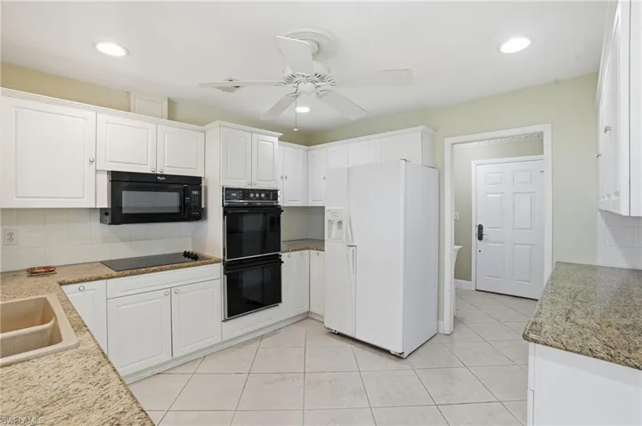 Kitchen featuring black appliances, white cabinets, tasteful backsplash, a ceiling fan, and recessed lighting
