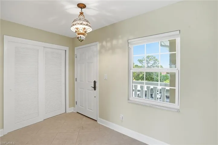 Entrance foyer featuring light tile patterned floors and hanging lights