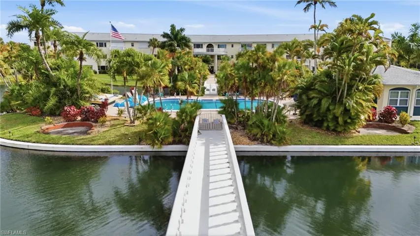 Dock featuring a water view, a lawn, and an outdoor pool