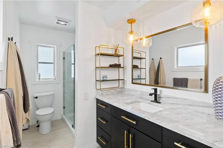 Full bathroom with vanity and a shower stall