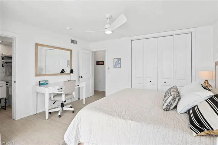 Bedroom featuring a closet, light wood-type flooring, ceiling fan, and a desk