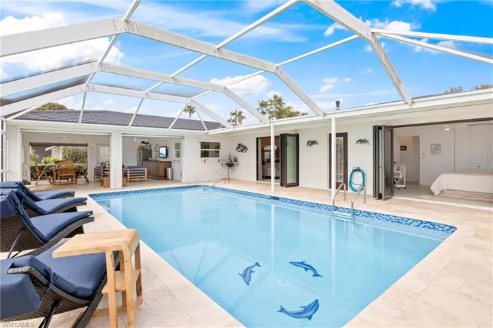 Outdoor pool with glass enclosure, outdoor dining area, a patio area, and a sunroom