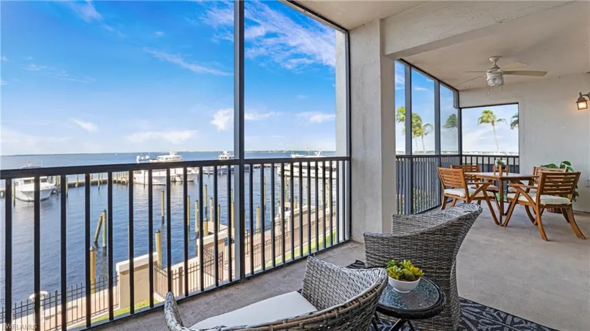 Sunroom / solarium featuring a water view, ceiling fan, and a balcony