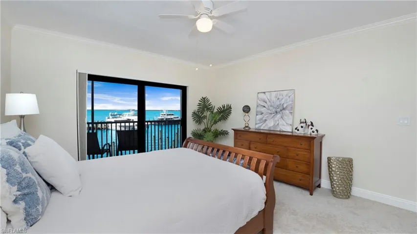 Bedroom featuring a water view, ornamental molding, light colored carpet, access to outside, and ceiling fan
