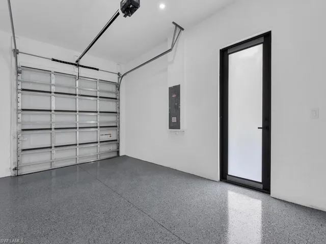 Garage featuring electric panel and a garage door opener