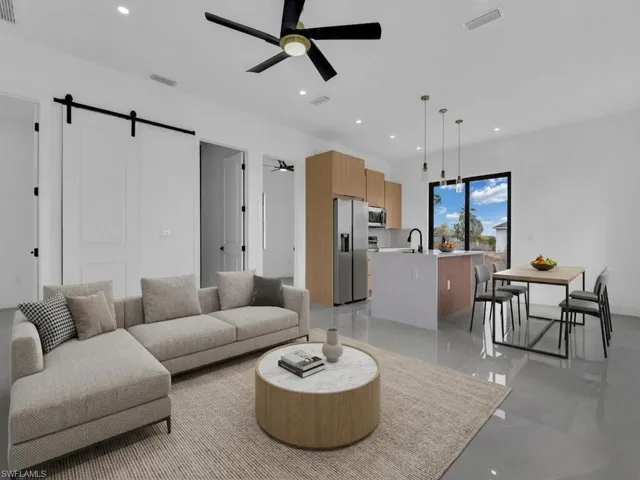 Living area featuring a barn door, a ceiling fan, and recessed lighting