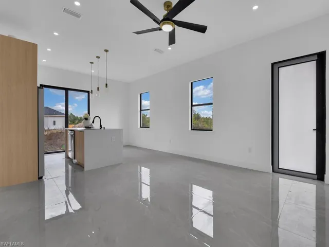 Unfurnished living room with finished concrete flooring, a ceiling fan, and recessed lighting