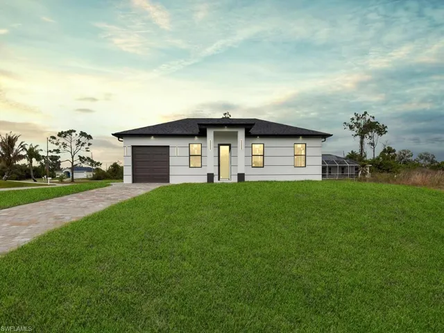 View of front of house featuring a yard, an attached garage, and driveway