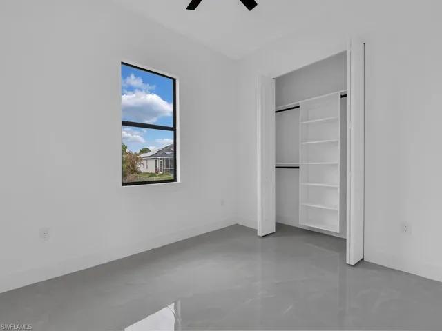 Unfurnished bedroom with a closet, finished concrete floors, and a ceiling fan