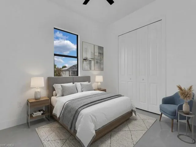 Bedroom with a closet, concrete flooring, and a ceiling fan