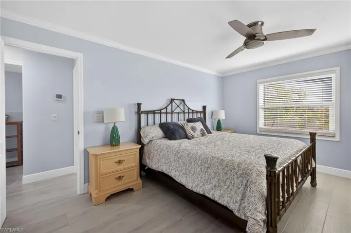 Bedroom featuring crown molding, a ceiling fan, connected bathroom, and light wood finished floor