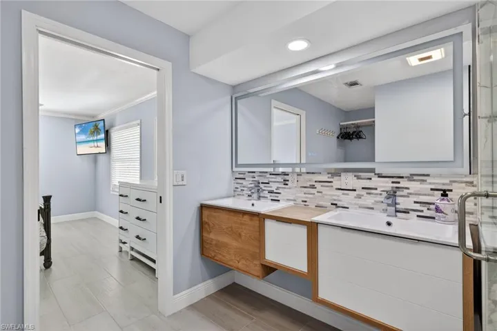 Full bathroom featuring vanity, backsplash, and crown molding