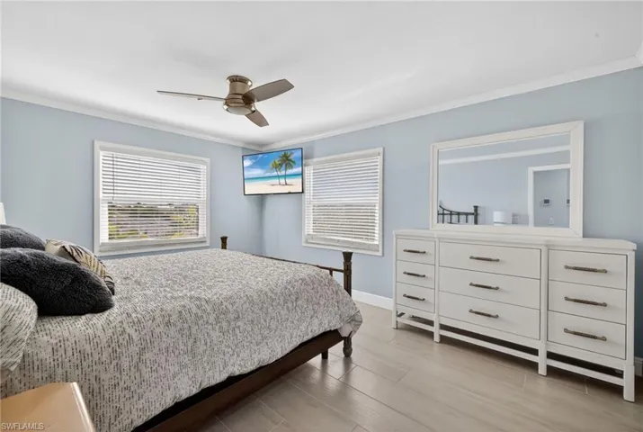 Bedroom featuring crown molding, a ceiling fan, connected bathroom, and tiled finished floor