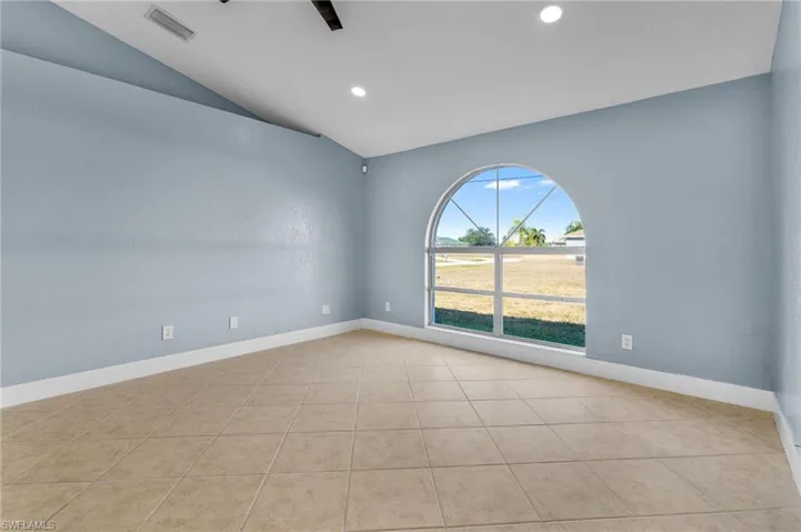 Spare room with vaulted ceiling, recessed lighting, and light tile patterned floors