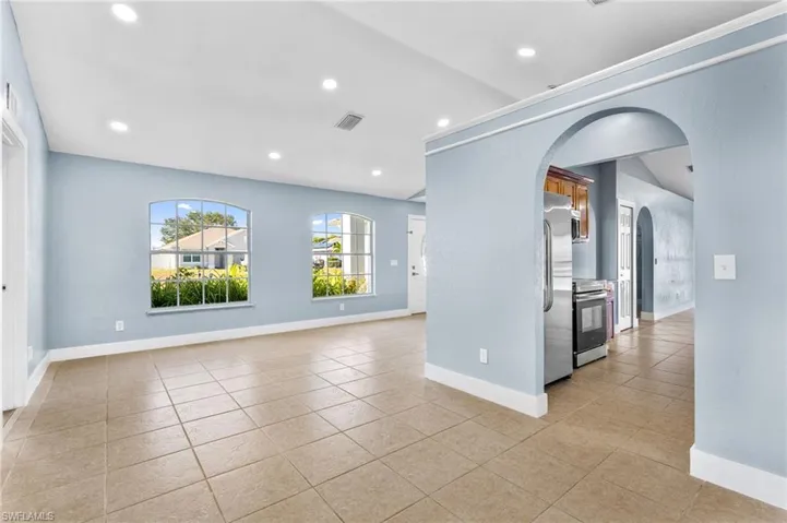 Spare room featuring arched walkways, recessed lighting, and light tile patterned floors