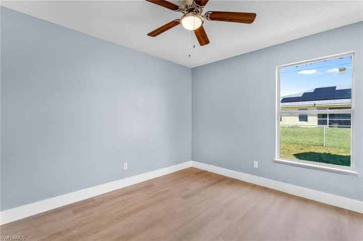 Empty room with light wood-style flooring and ceiling fan
