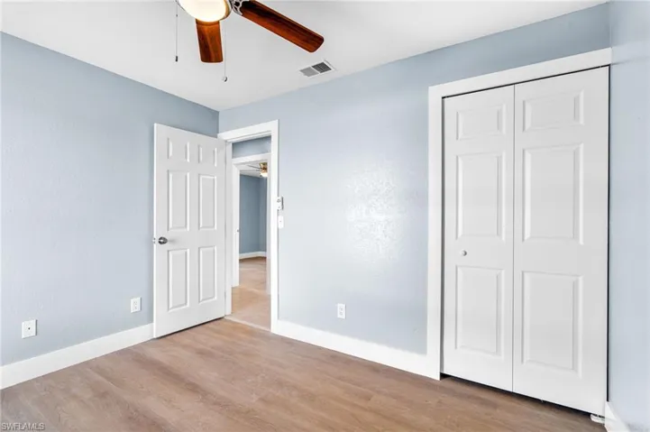 Unfurnished bedroom featuring light wood-type flooring, ceiling fan, and a closet