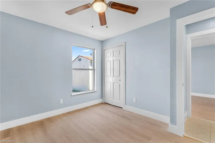 Unfurnished bedroom with light wood-style flooring, a closet, and ceiling fan