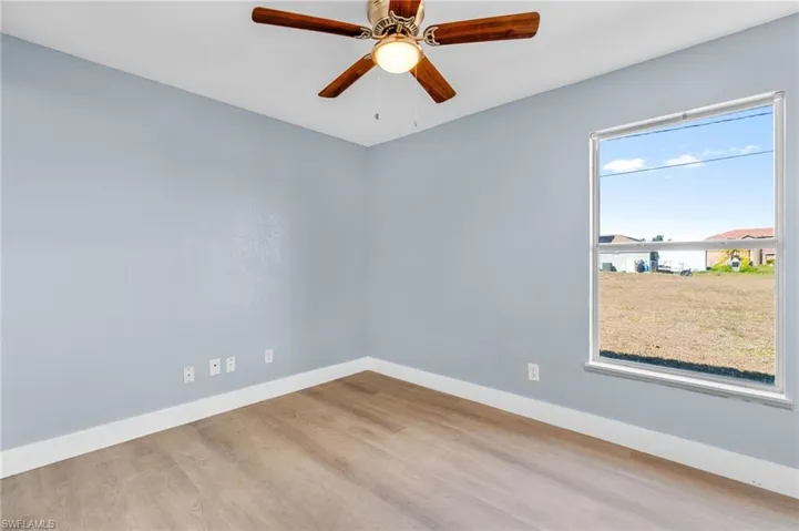 Empty room featuring light wood finished floors and ceiling fan