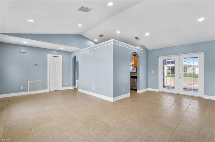 Spare room with french doors, arched walkways, recessed lighting, and light tile patterned flooring