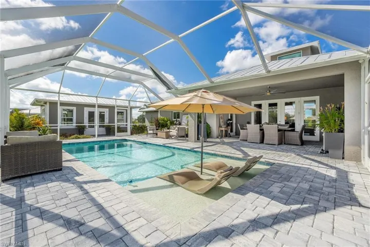 View of swimming pool with french doors, a patio area, a lanai, ceiling fan, and an outdoor living space